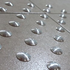 Tactile stud aluminum overlay without adhesive
