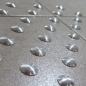 Tactile stud aluminum overlay without adhesive